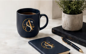 Amera Salem branded mug and notebook on a desk